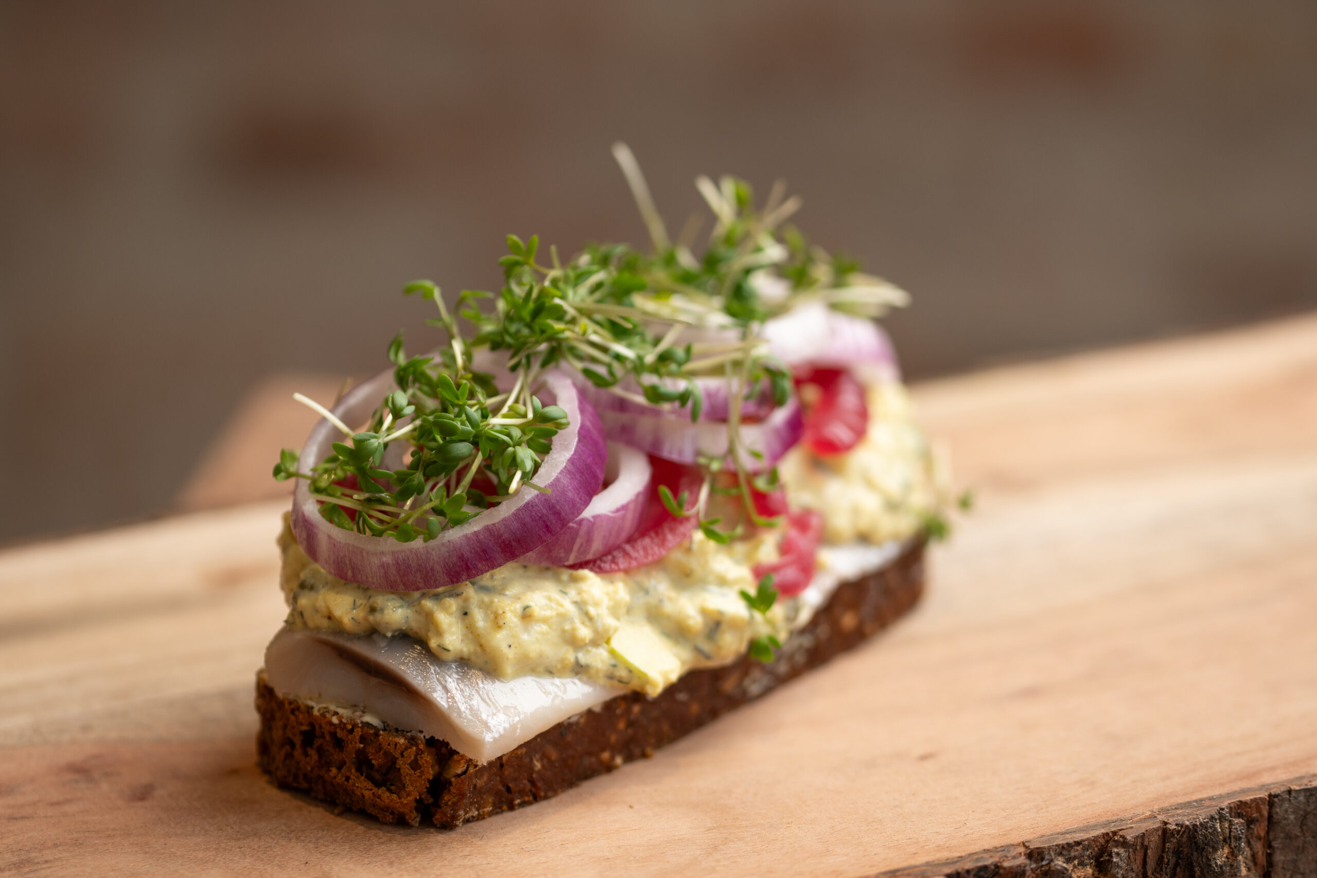 Dansk smørrebrød med sild, løg og karse