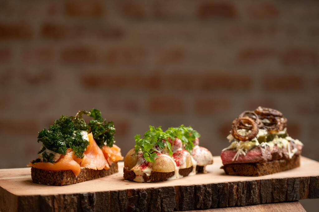 Tre forskellige smørrebrød på træplade