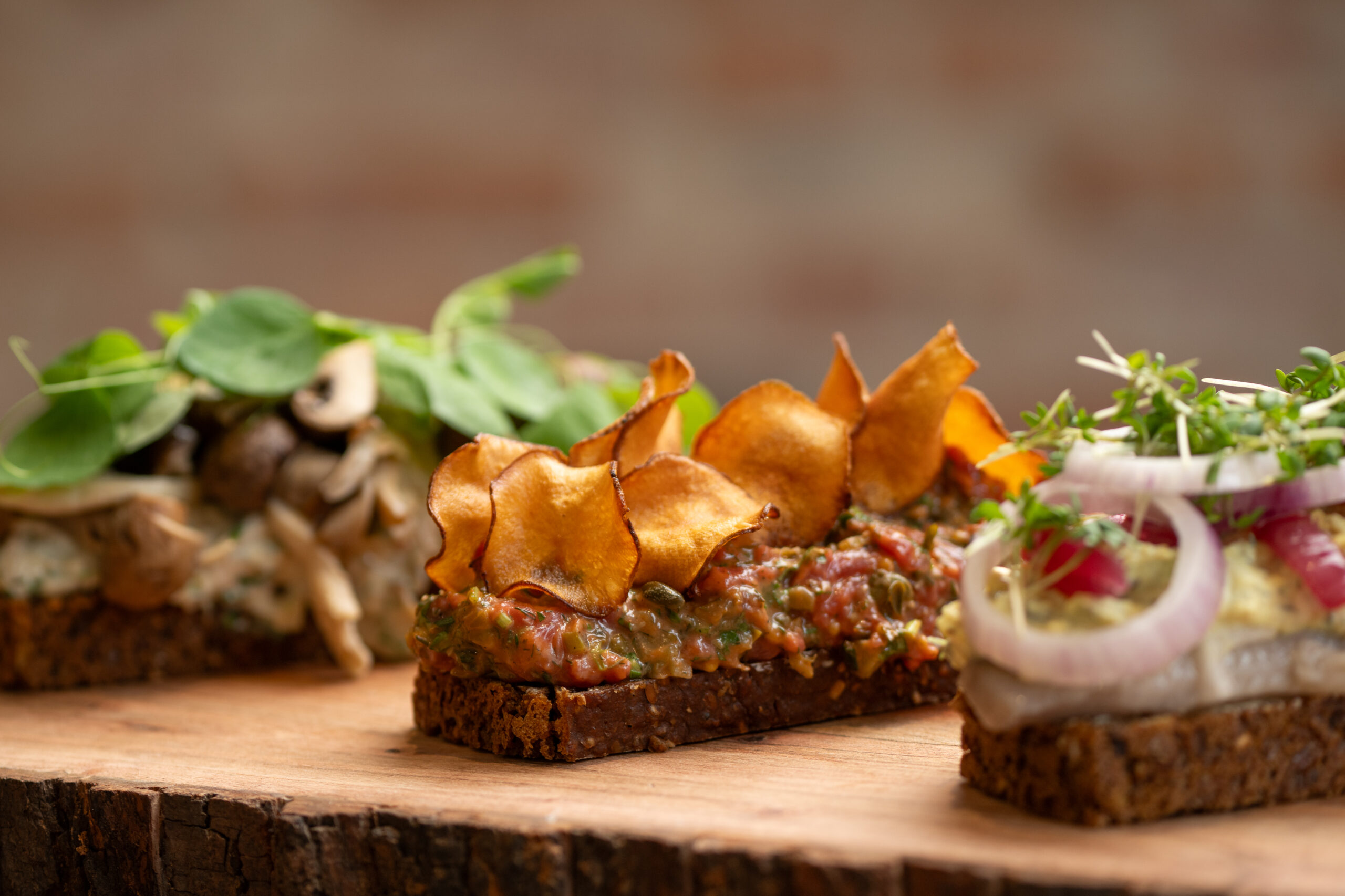 Lækre smørrebrød med forskellige toppings på træbord